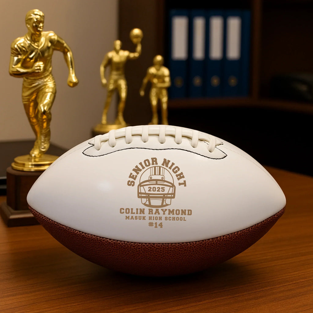 Senior Night Football Award laser engraved with a player's name, jersey number, high school and year, displayed on a desk beside gold football trophies