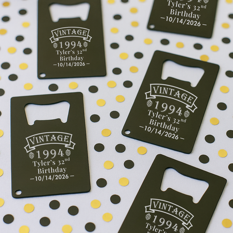 Personalized credit card bottle openers engraved with a name, age and party date, laid on gold confetti as birthday party favors for men