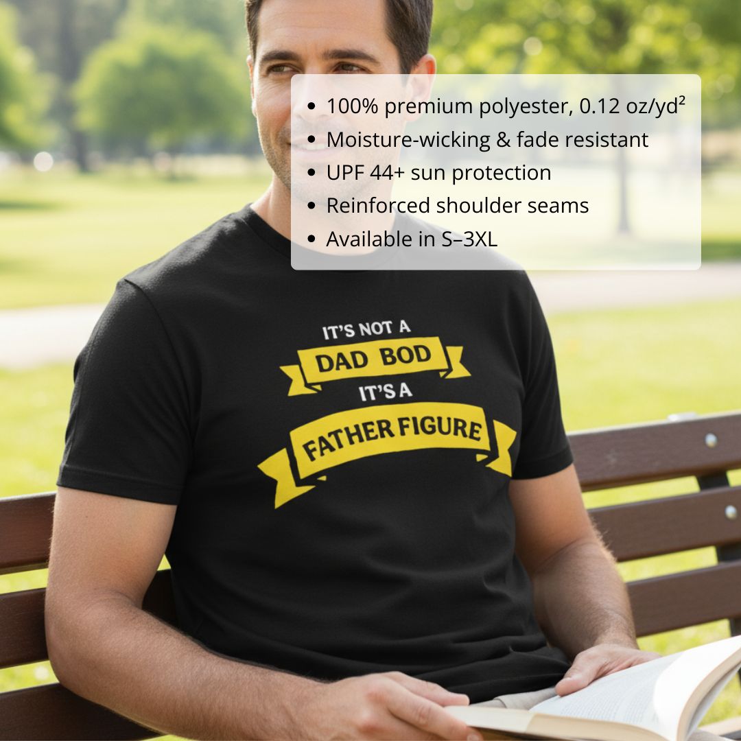 Black crewneck t-shirt with yellow banner graphic reading "It's Not a Dad Bod It's a Father Figure" worn outdoors on a park bench
