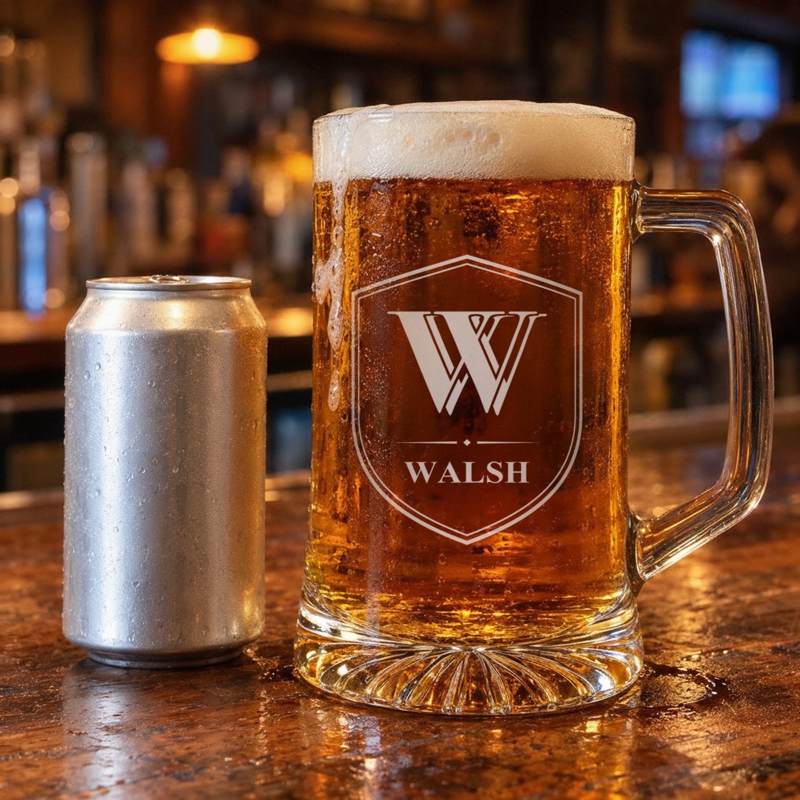 25 oz monogram beer stein beside a standard 12 oz beer can on a bar for size, engraved with a Shield Crest showing the initial W and the name Walsh