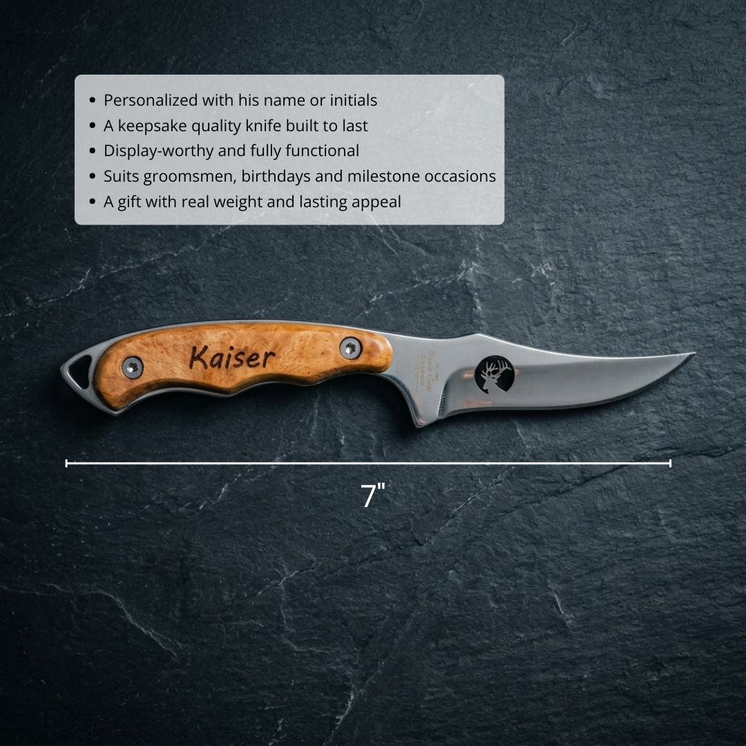 Personalized hunting knife with wood handle engraved with sample name "Kaiser" and deer motif on blade, displayed at 7-inch length on dark slate background