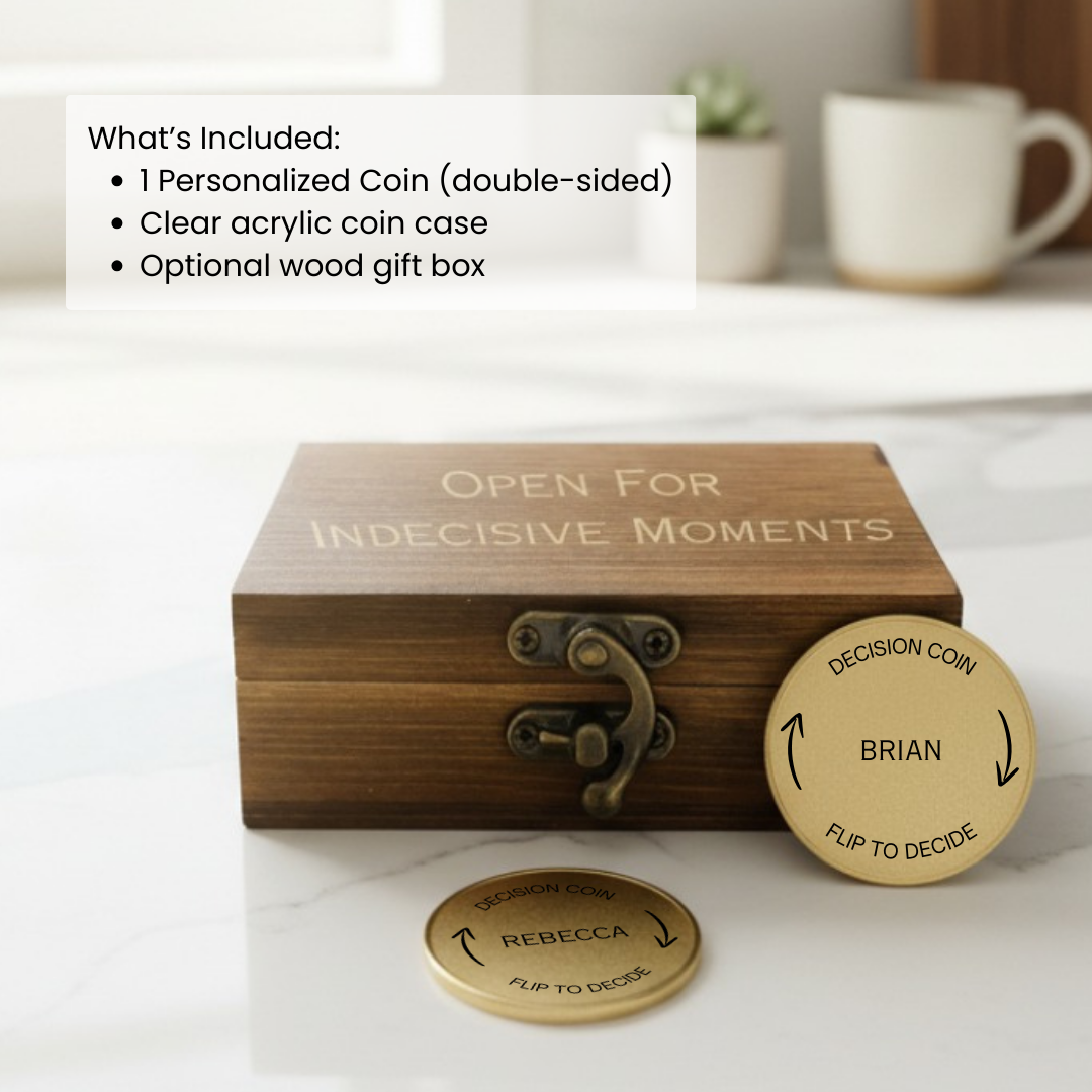 Wooden gift box engraved "Open For Indecisive Moments" with two personalized brass coins showing sample names "Brian" and "Rebecca" with flip-to-decide arrows