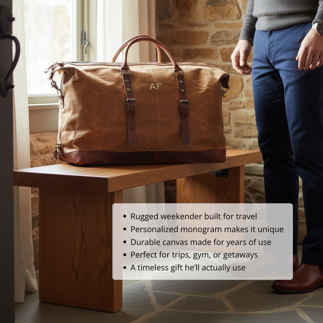 Tan waxed canvas weekender bag with cognac leather handles and base, monogrammed with sample initials "AF" on front, displayed on wooden table in home interior setting