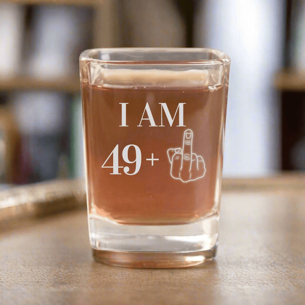 The original 50th birthday shot glass photo: I AM 49 plus a middle finger engraved on a square glass, a funny gift for the big birthday party