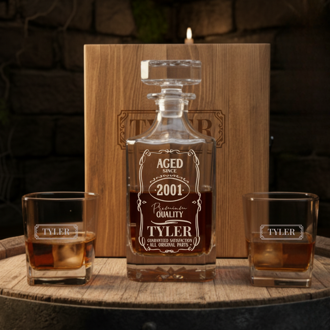 Personalized whiskey decanter set with "Aged Since 2001" label engraved on glass decanter, matching glasses engraved with sample name "Tyler", displayed with wooden presentation case