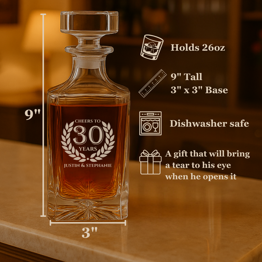 Crystal whiskey decanter engraved with sample "CHEERS TO 30 YEARS" laurel wreath design and names "JUSTIN & STEPHANIE", filled with amber liquid, displayed with spec callouts for 26oz capacity and 9" height