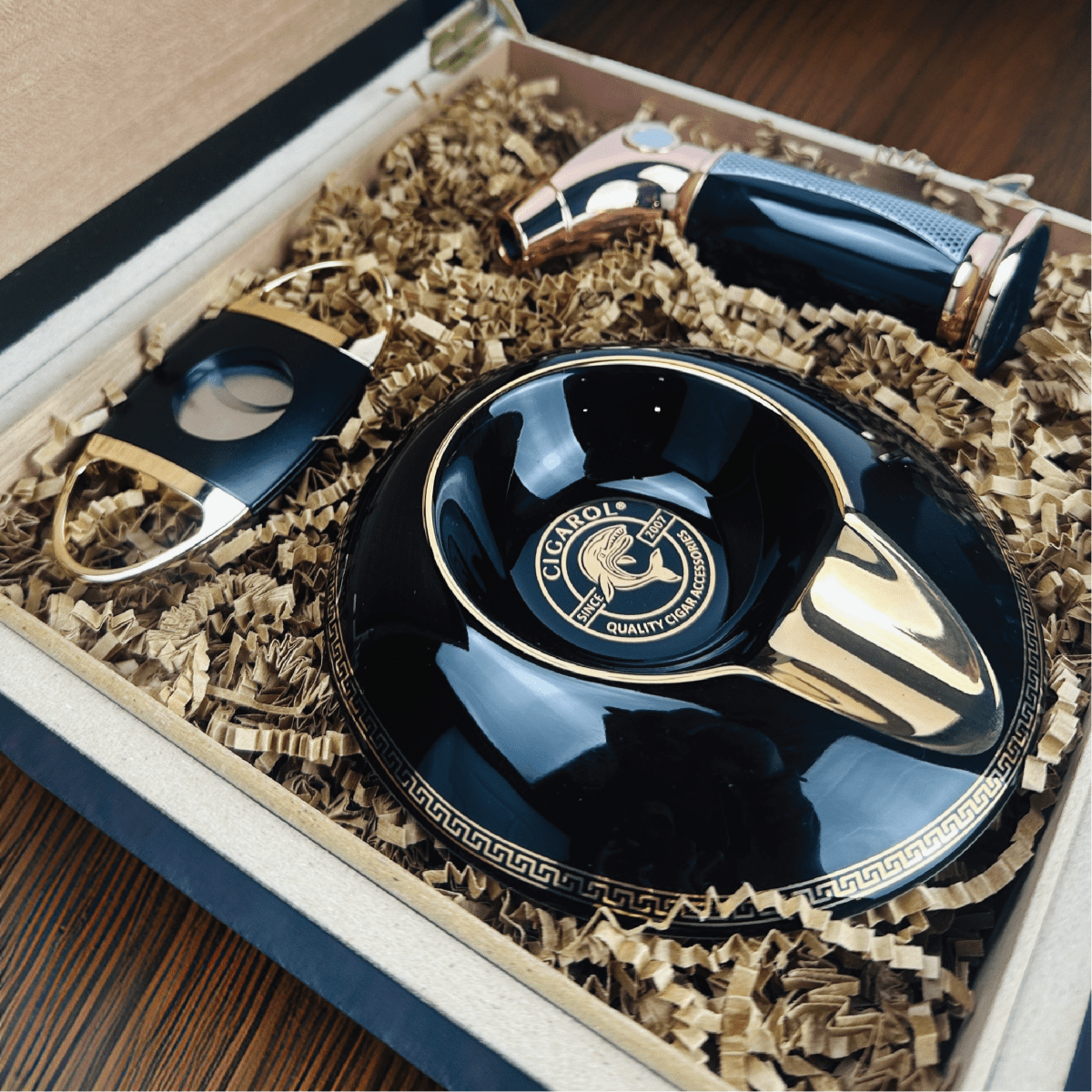 Personalized cigar gift set featuring a black and gold ashtray, cigar torch lighter, and cutter inside a custom engraved gift box.