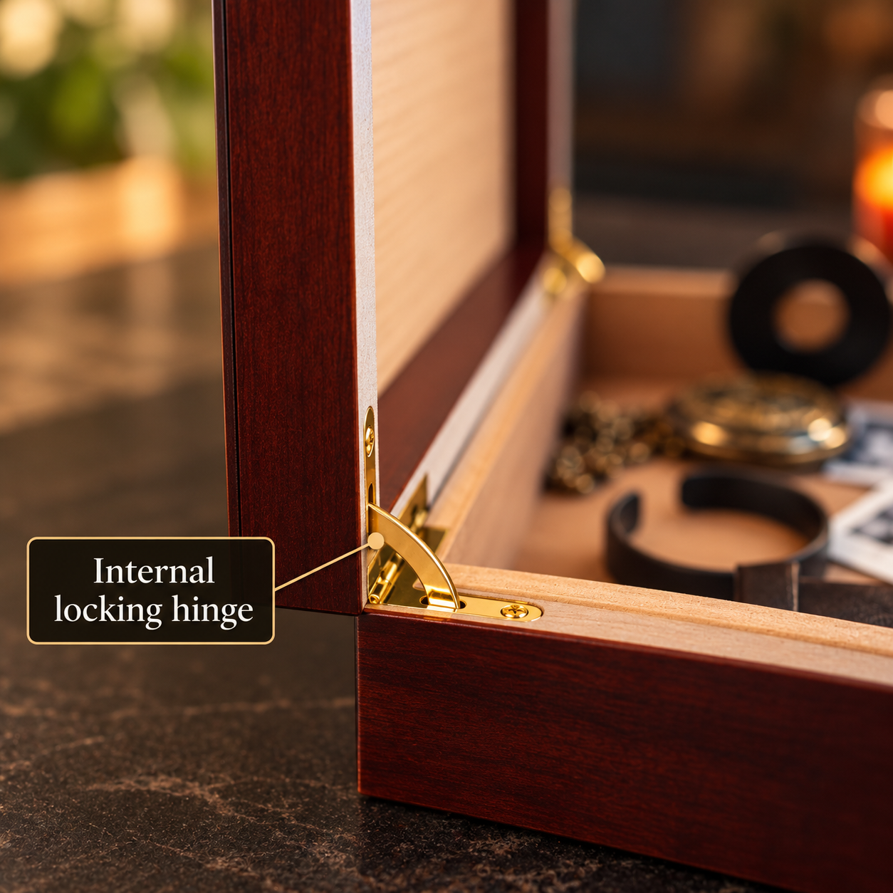 Close-up of the brass hinge and Spanish cedar lining on an open cherry keepsake box, with a wristwatch and a leather strap resting inside the lined interior.