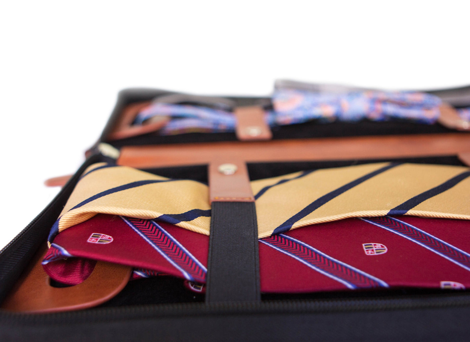 Brown vegan leather travel tie case with plush black interior, holds ties, cufflinks, and clips.