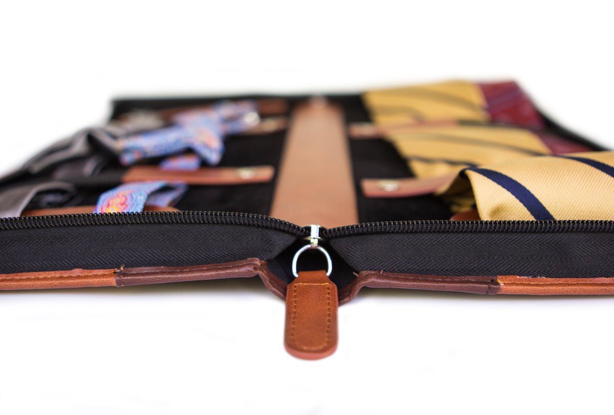 Brown vegan leather travel tie case with plush black interior, holds ties, cufflinks, and clips.