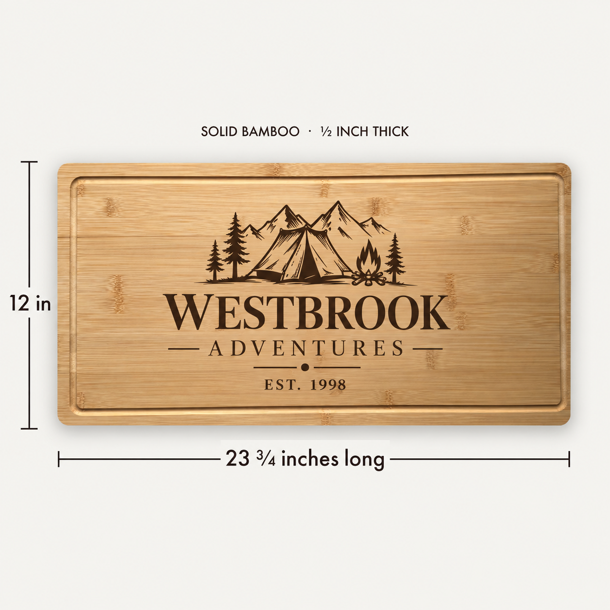 A rectangular solid bamboo cutting board with engraved mountain, tent, trees, and the text 'WESTBROOK ADVENTURES EST. 1998'.