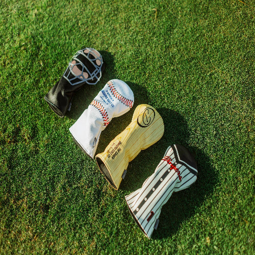 Four golf club head covers on a grassy background
