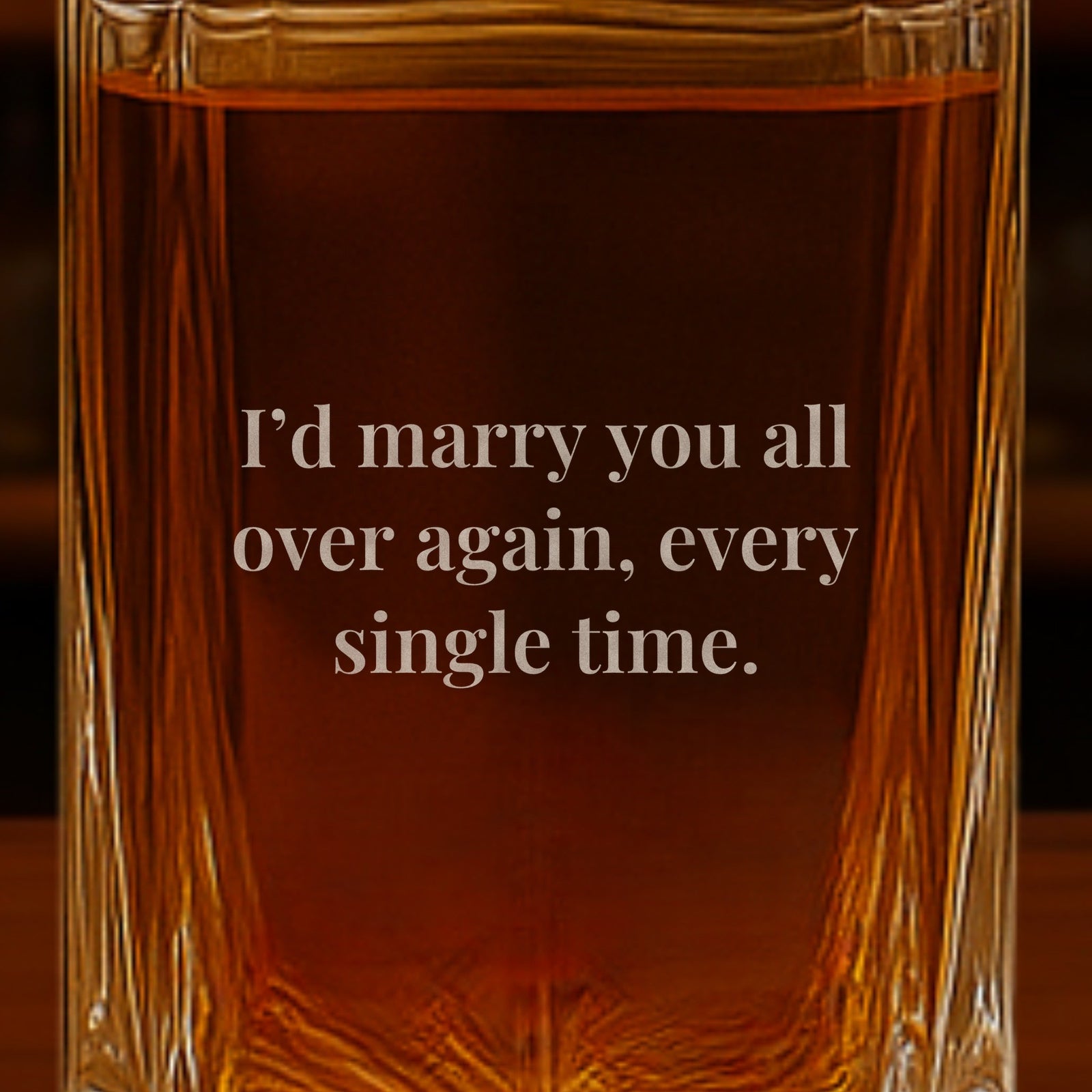 Close-up of an anniversary message engraved on the back of a whiskey decanter for husband that reads I'd marry you all over again, every single time