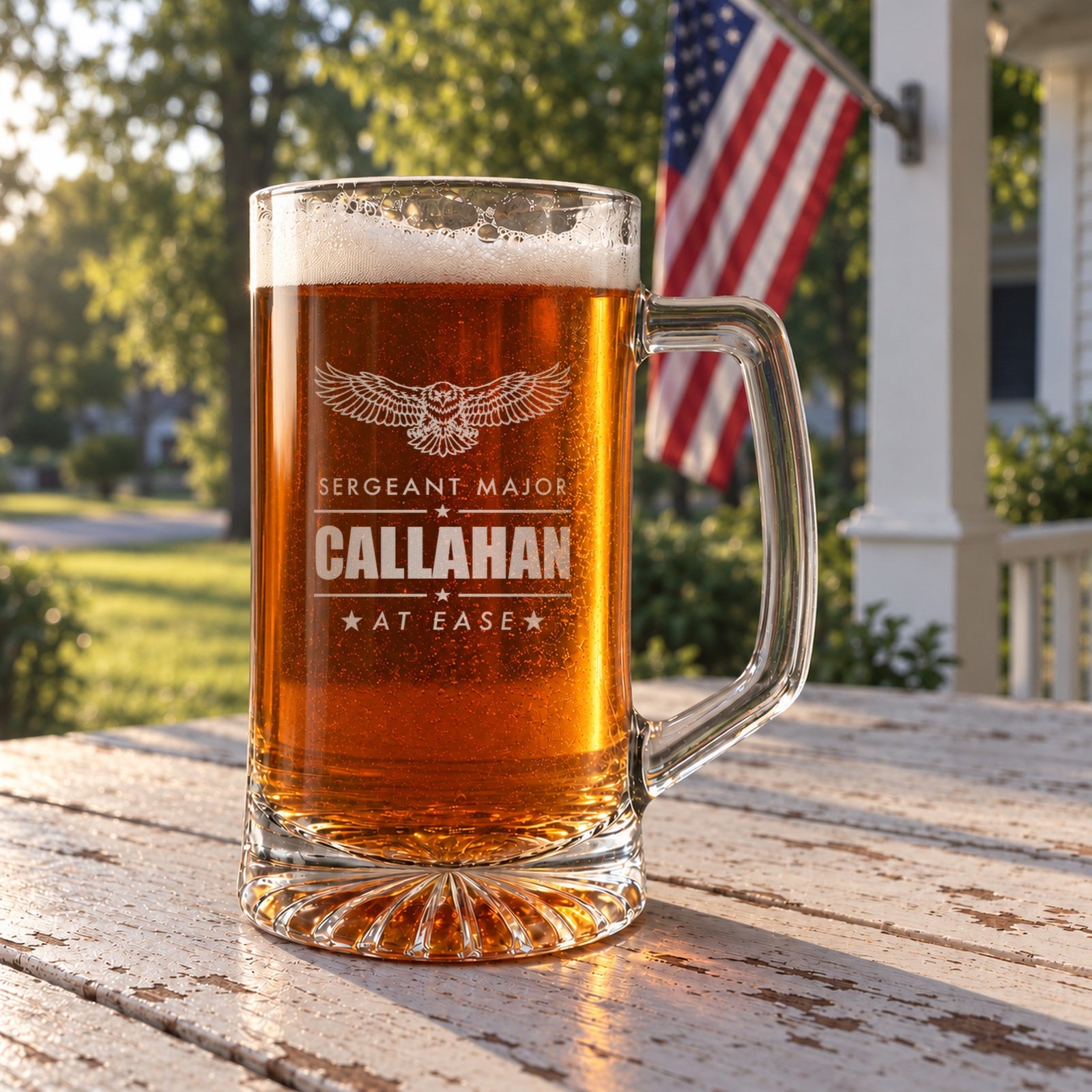 Army retirement beer stein on a front porch table with an American flag behind it, engraved with an eagle, Sergeant Major, Callahan and At Ease