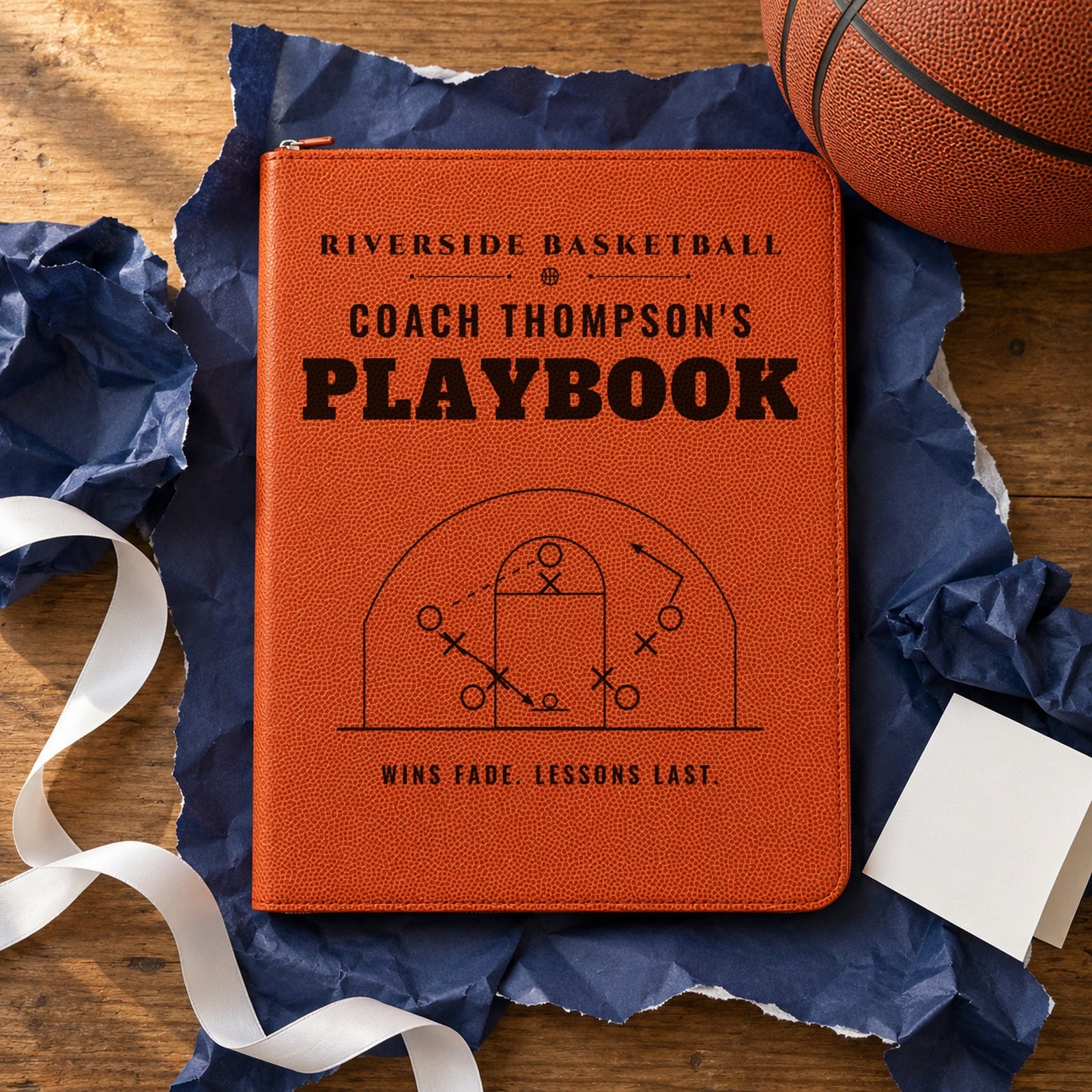 Basketball coach portfolio engraved Riverside Basketball, Coach Thompson's Playbook, Wins fade. Lessons last., unwrapped on navy paper as a team gift