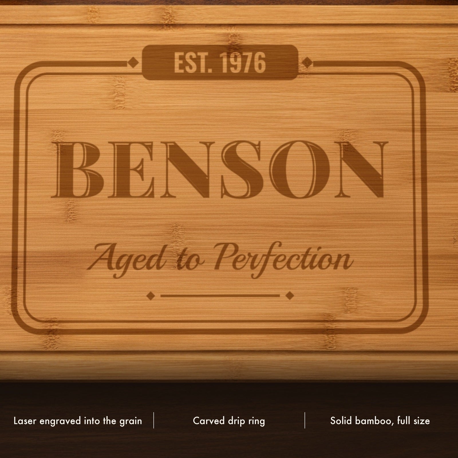 Close-up of the laser engraved birthday cutting board showing the vintage name lettering and script line burned into the bamboo grain