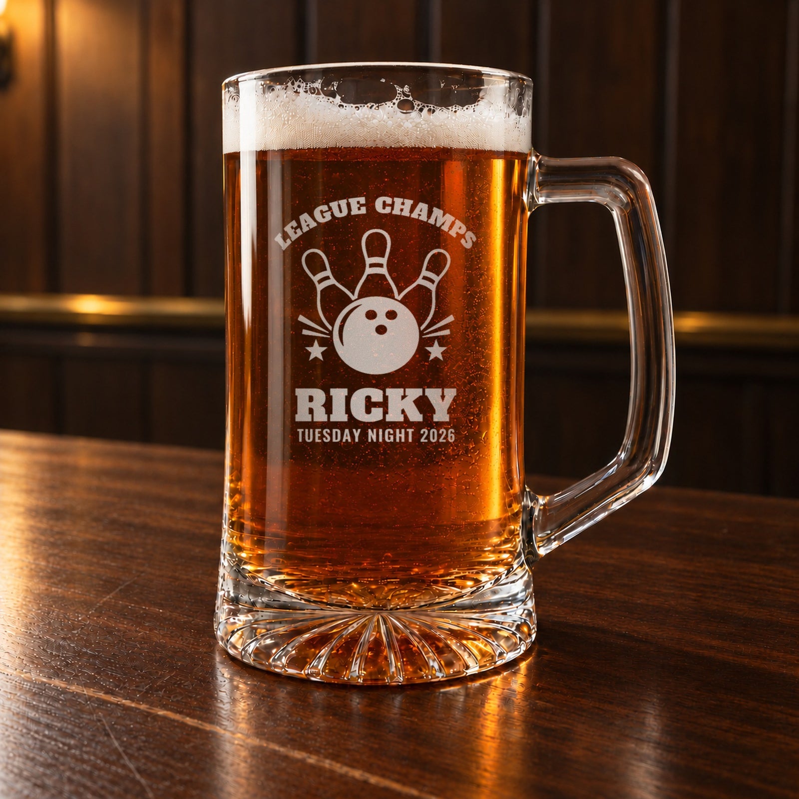 Personalized bowling beer mug on a walnut bar, engraved with a bowling ball and three pins: League Champs, Ricky, Tuesday Night 2026