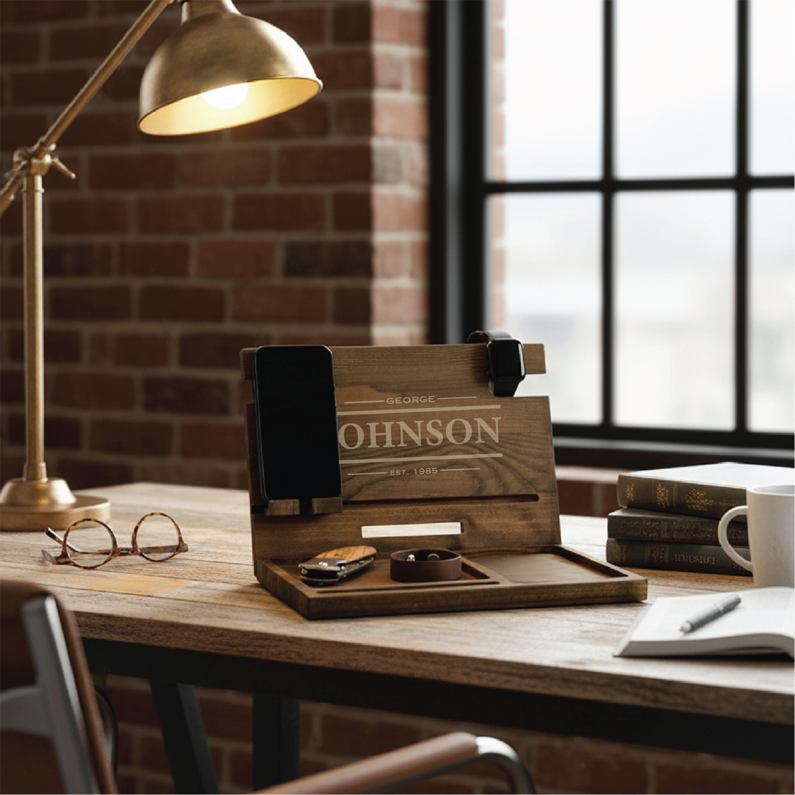 Wood desk organizer with laser-engraved sample personalization reading "GEORGE JOHNSON EST. 1985," featuring compartments for phone, watch, wallet, and keys on office desk