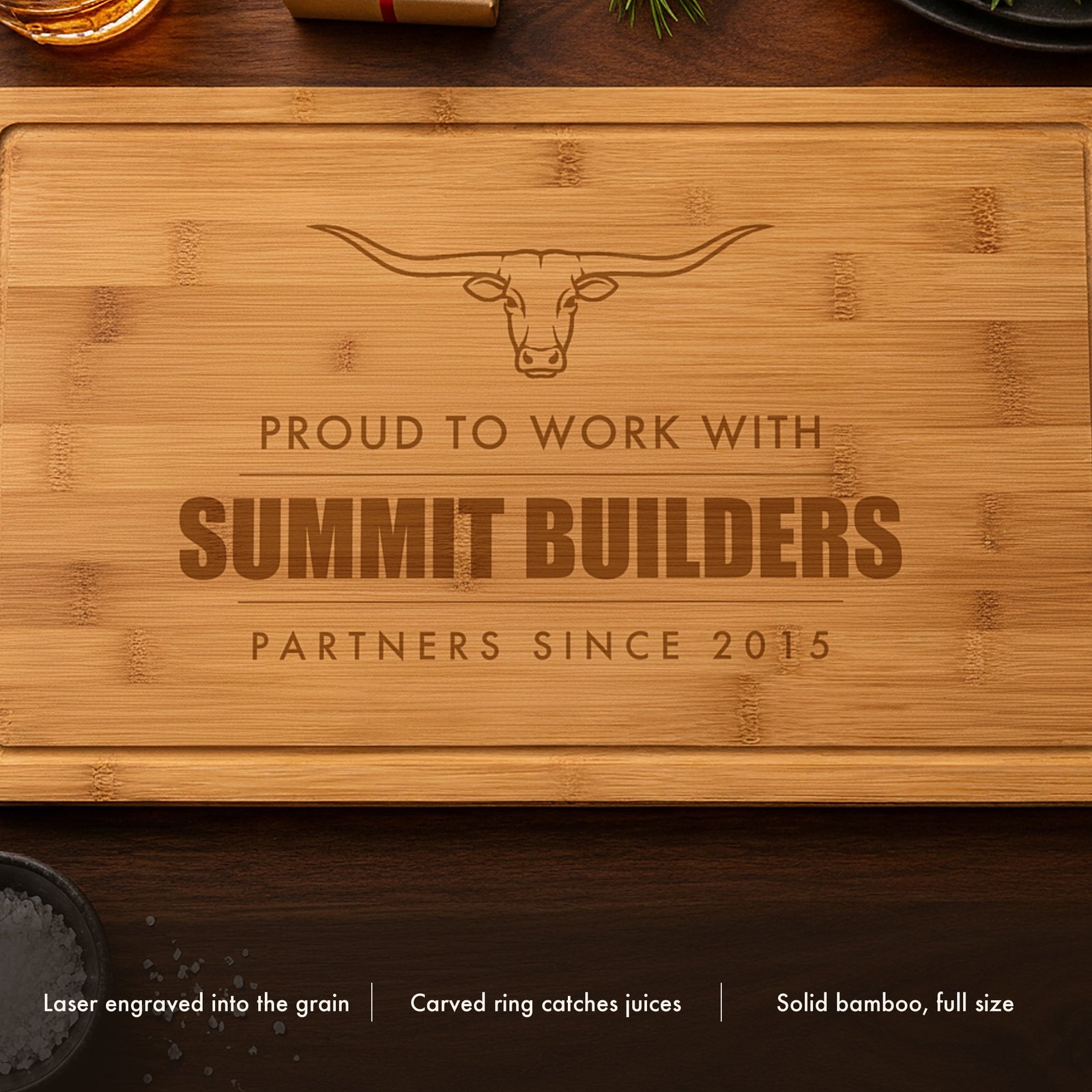 Close-up of the laser engraved corporate gift cutting board showing the longhorn steer and the client company name burned into the bamboo grain