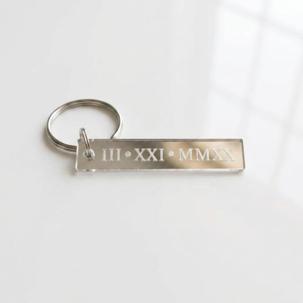 Metal keychain with Roman numeral and year engraving on a white background