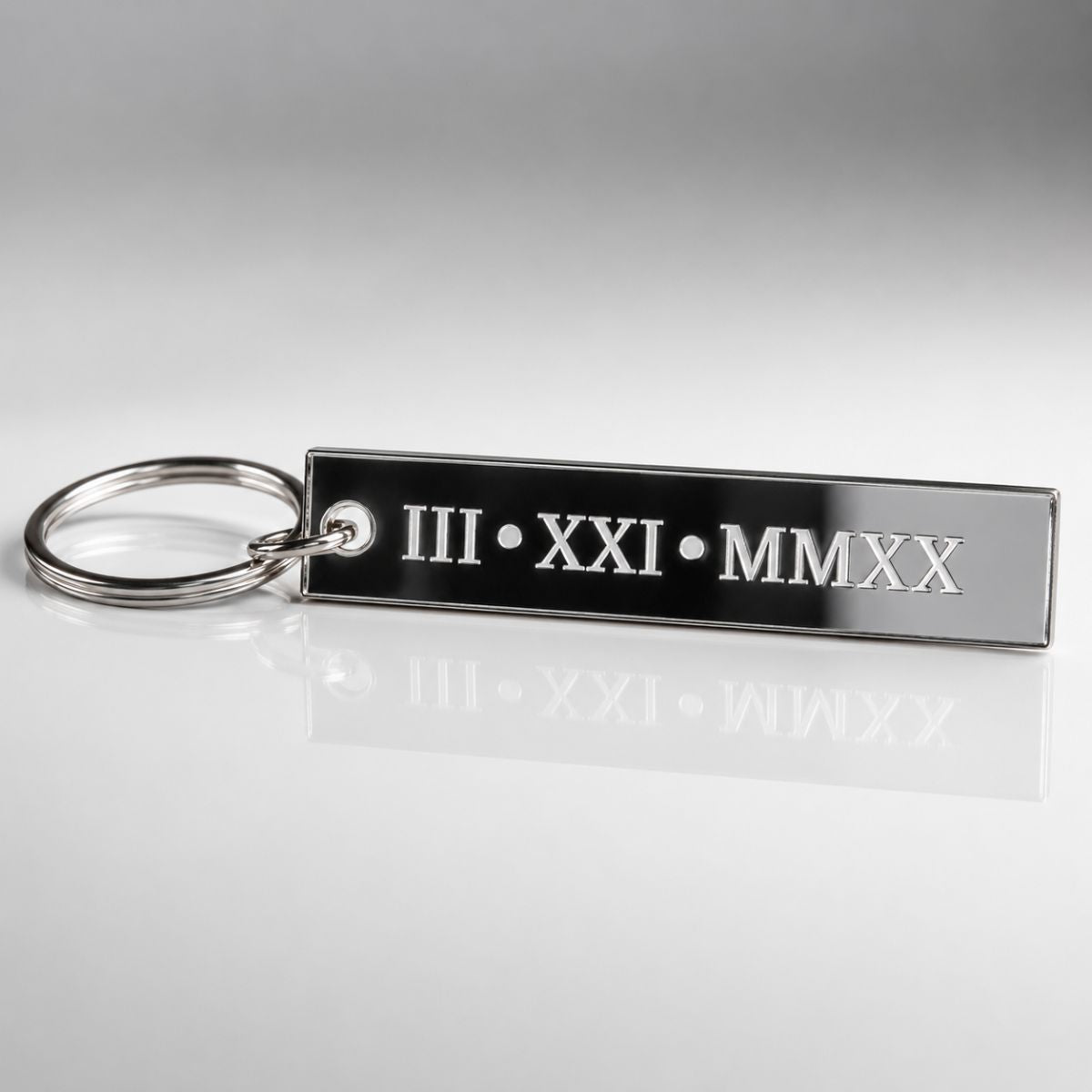 Keychain with Roman numerals and year on a reflective surface