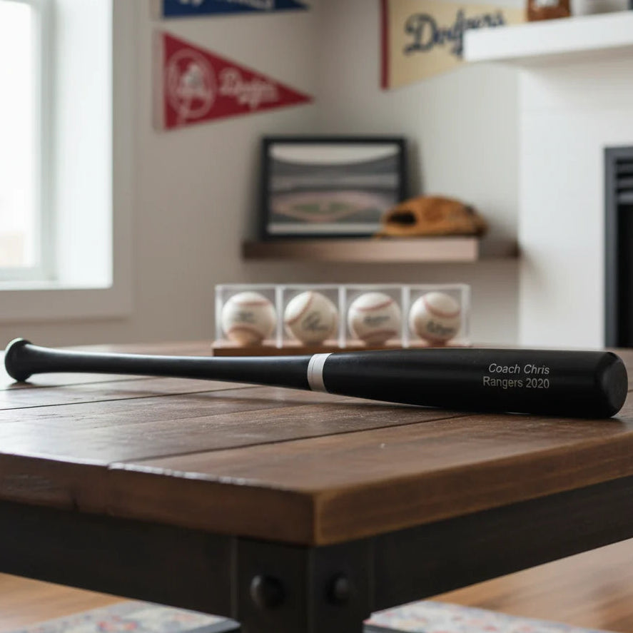 Personalized Rawlings Baseball bat with Baseball Coach Name and Team and Year on It sitting on a wooden table