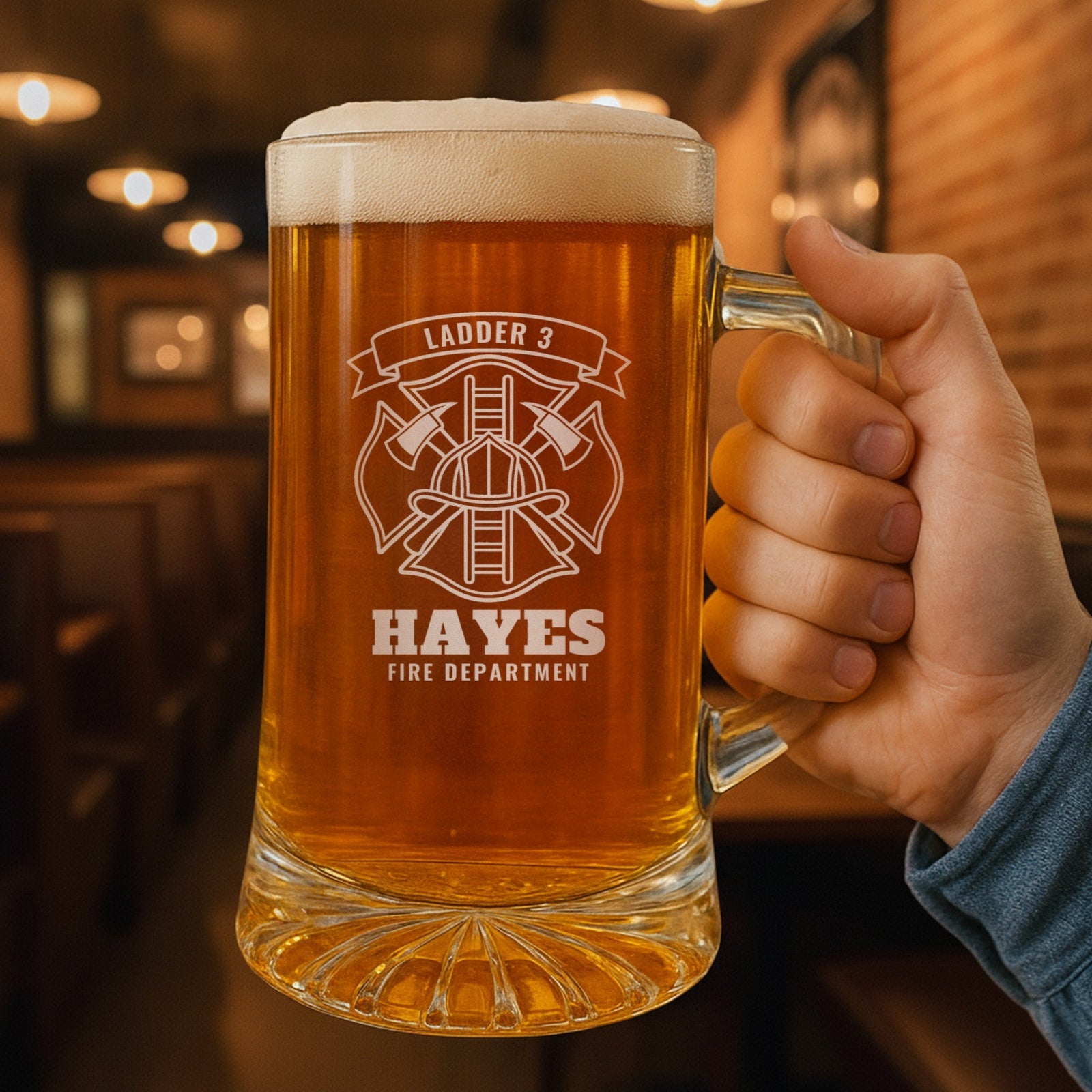 Hand holding a 25 oz personalized firefighter beer stein in a pub, engraved with the Maltese cross, Ladder 3, Hayes and Fire Department