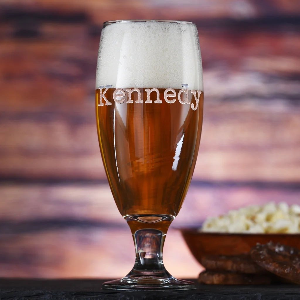 Real photo of the Goblet Mark personalized beer goblet filled with amber ale, sand-carved with the name Kennedy across the bowl