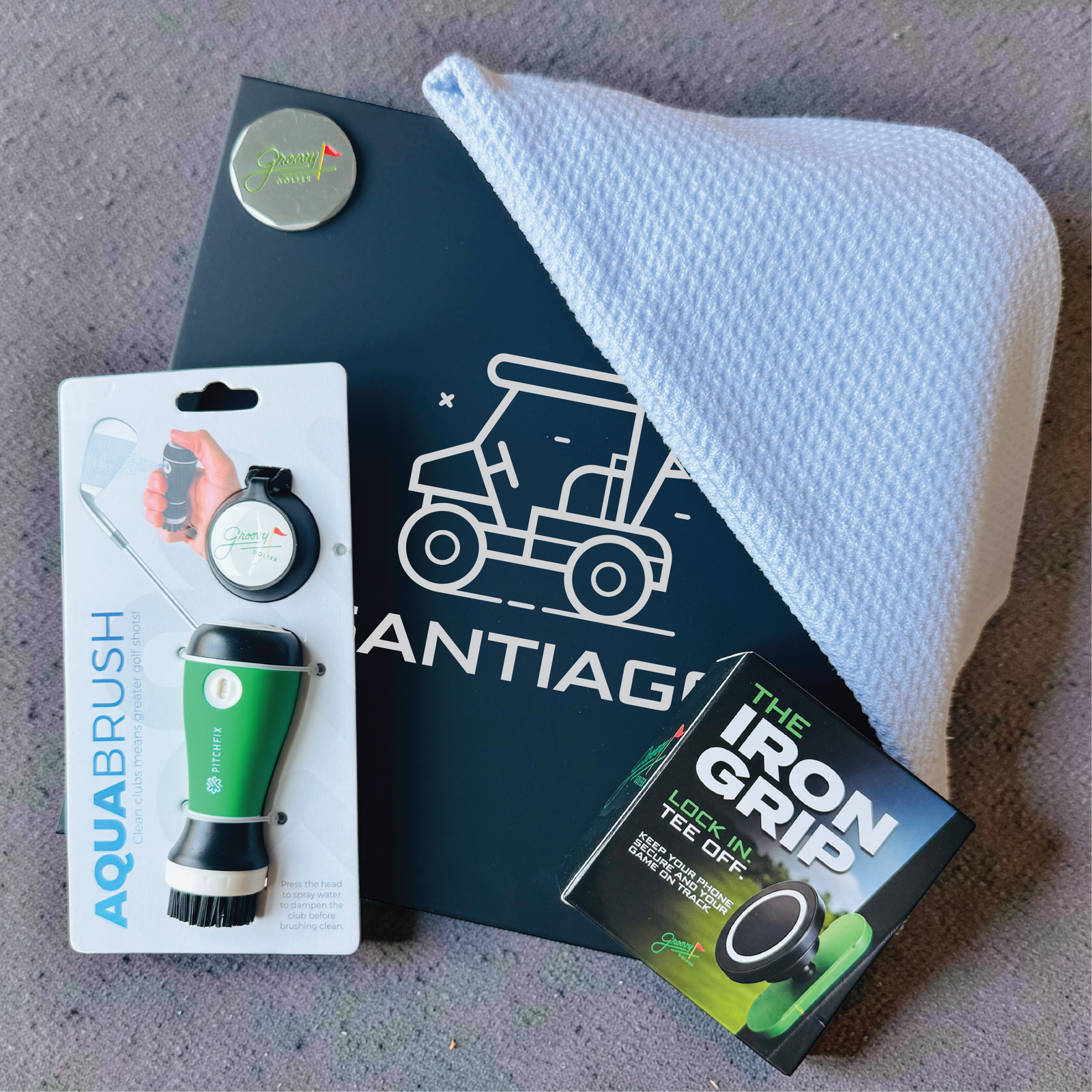 Golfer's gift box featuring a name-engraved keepsake box, club cleaner, waffle microfiber towel, ball marker and magnetic phone mount.