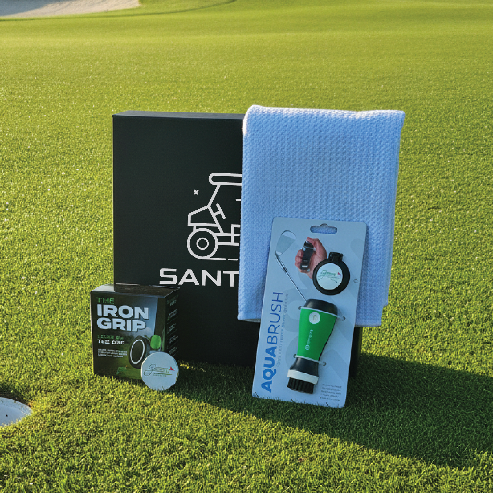 Engraved golfer's gift box shown with its magnetic phone mount, club cleaner, towel and ball marker.