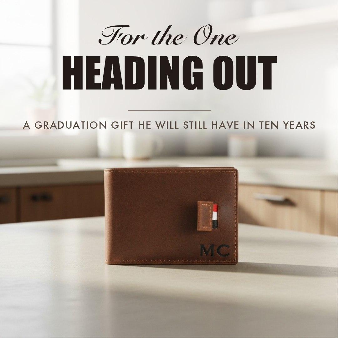 Brown leather bifold wallet engraved with initials, captioned For the One Heading Out, shown as a personalized graduation gift for him.
