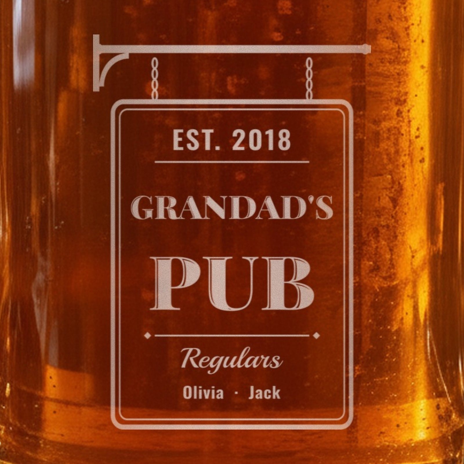 Close-up of the frosted laser engraving on the Grandpa's Pub stein: a bracket, chains and a sign reading Est. 2018, Grandad's Pub, Regulars Olivia and Jack