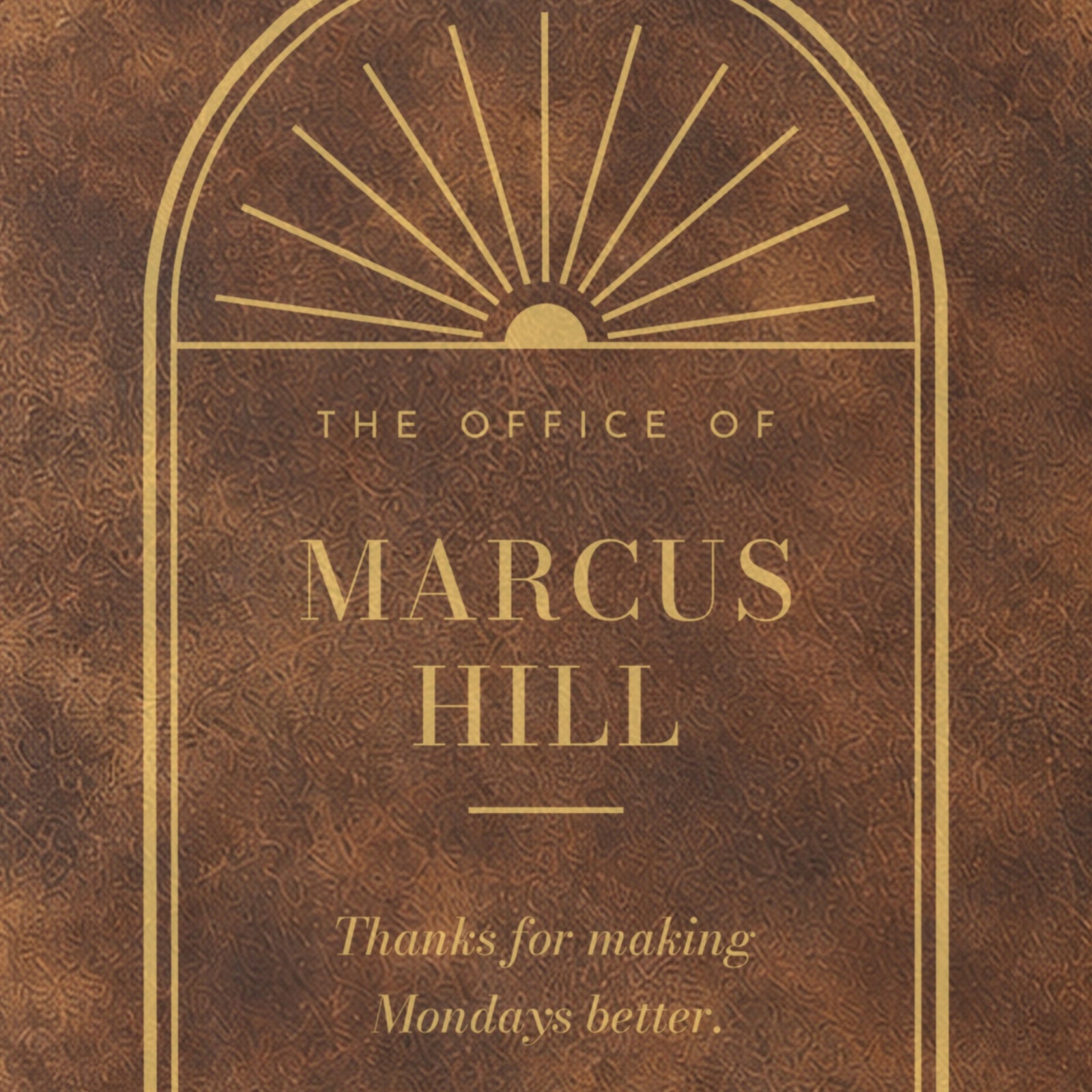 Close-up of the engraving on the Corner Office journal: the arched sunburst window above The Office of Marcus Hill in tall capitals