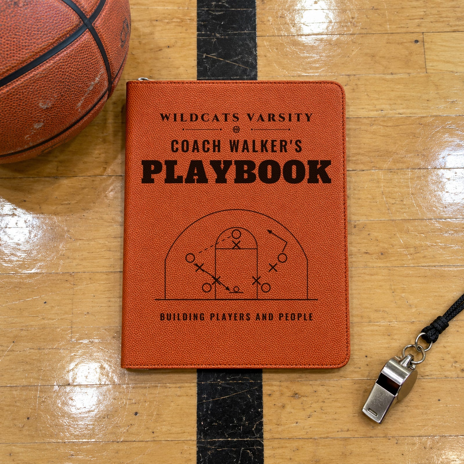 Personalized basketball coach portfolio engraved Wildcats Varsity, Coach Walker's Playbook, Building players and people, on a gym floor by a ball