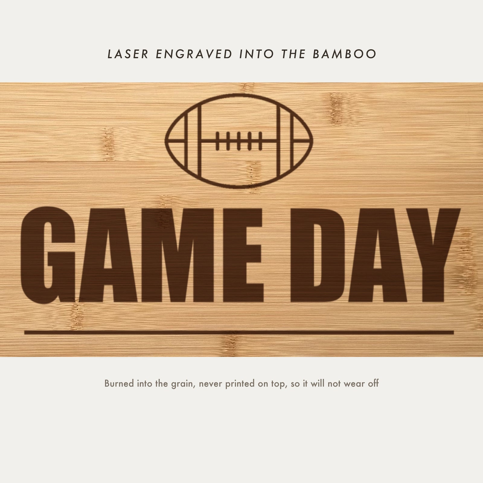 Close view of the football outline and Game Day laser engraved into the bamboo grain in heavy block capitals above the family line.