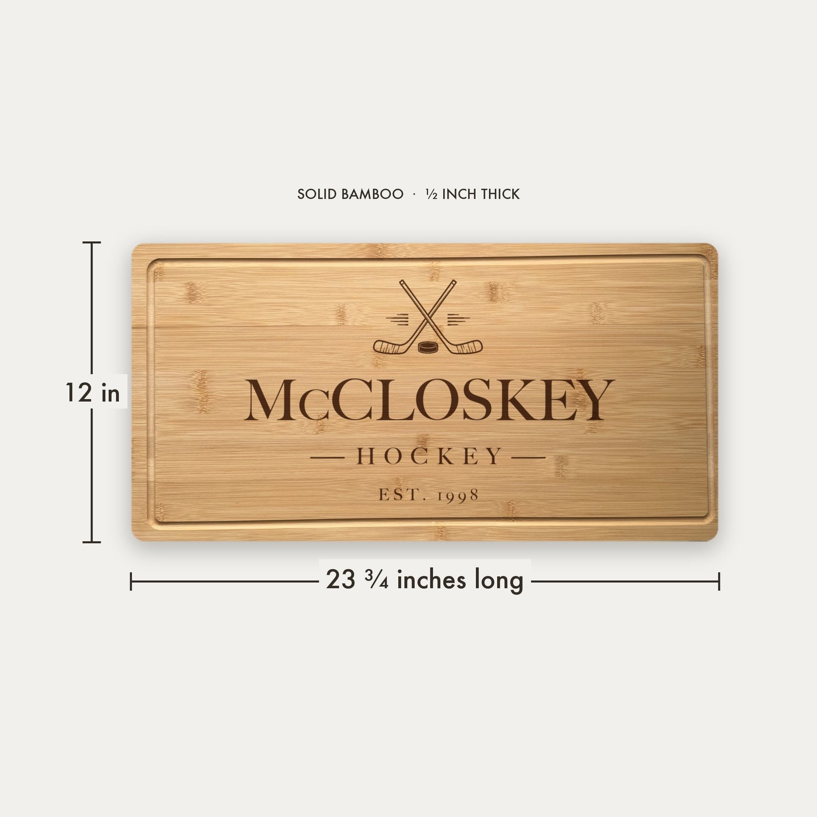 Size guide for the personalized hockey cutting board, 23 and three quarter inches long by 12 inches wide in half inch thick solid bamboo.