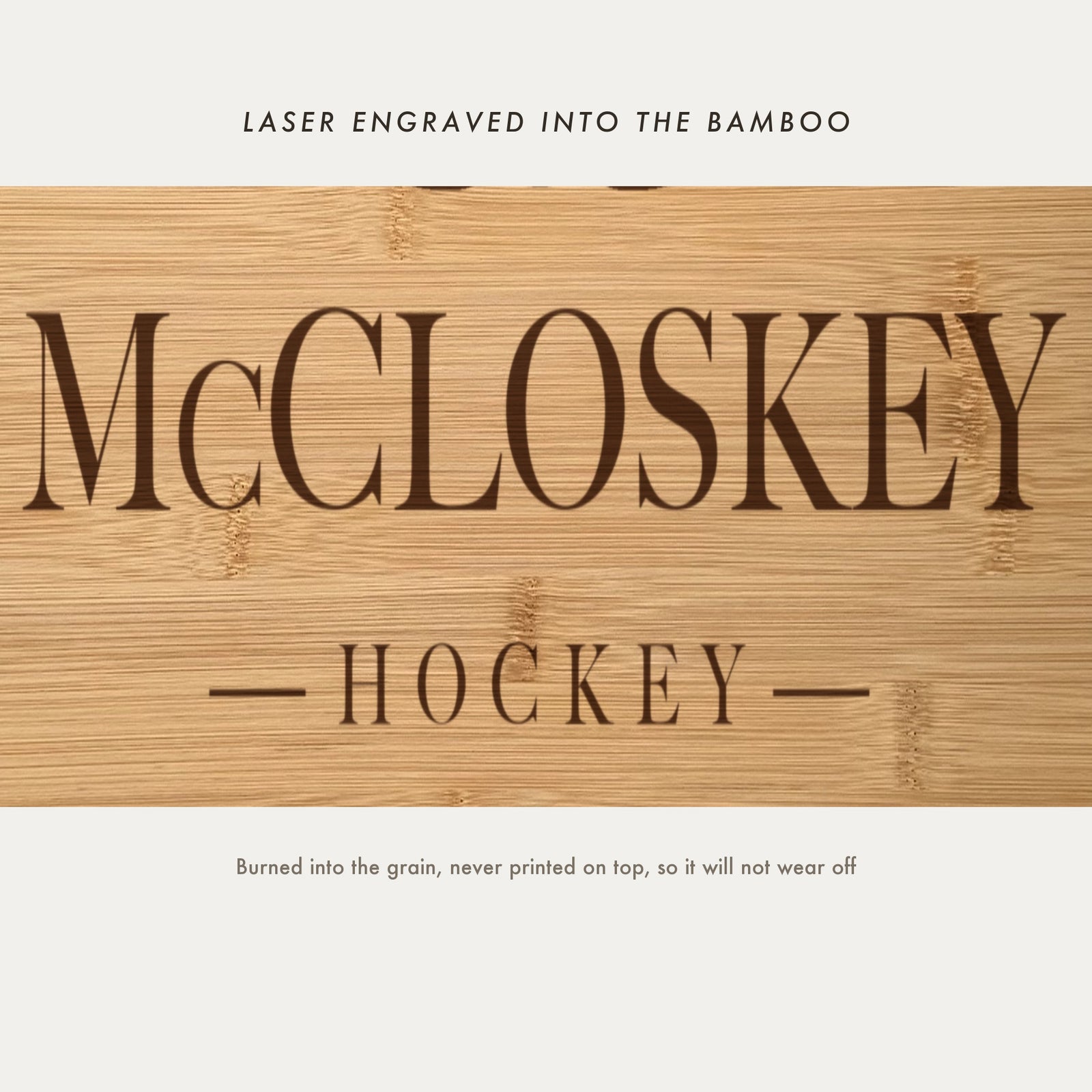 Close view of the family name and the word Hockey laser engraved into the bamboo grain in spaced serif capitals between two fine rules.