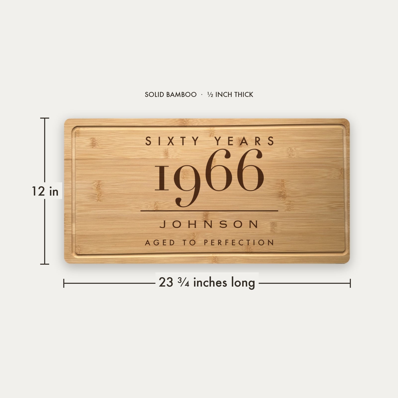 Size guide for the personalized milestone birthday cutting board, 23 and three quarter inches long by 12 inches wide in half inch thick solid bamboo.