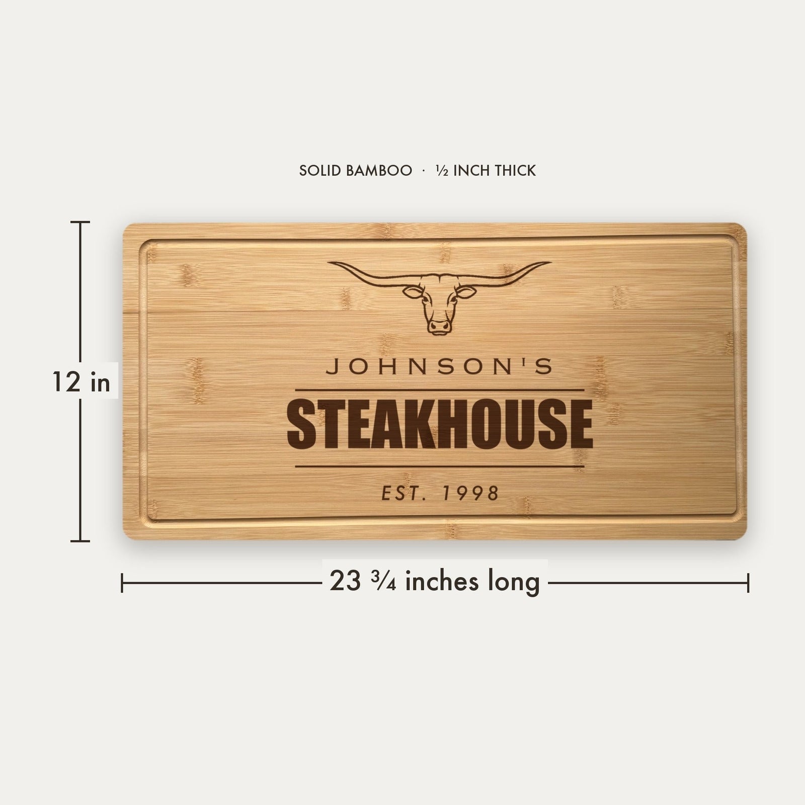 Size guide for the personalized steakhouse cutting board, 23 and three quarter inches long by 12 inches wide in half inch thick solid bamboo.