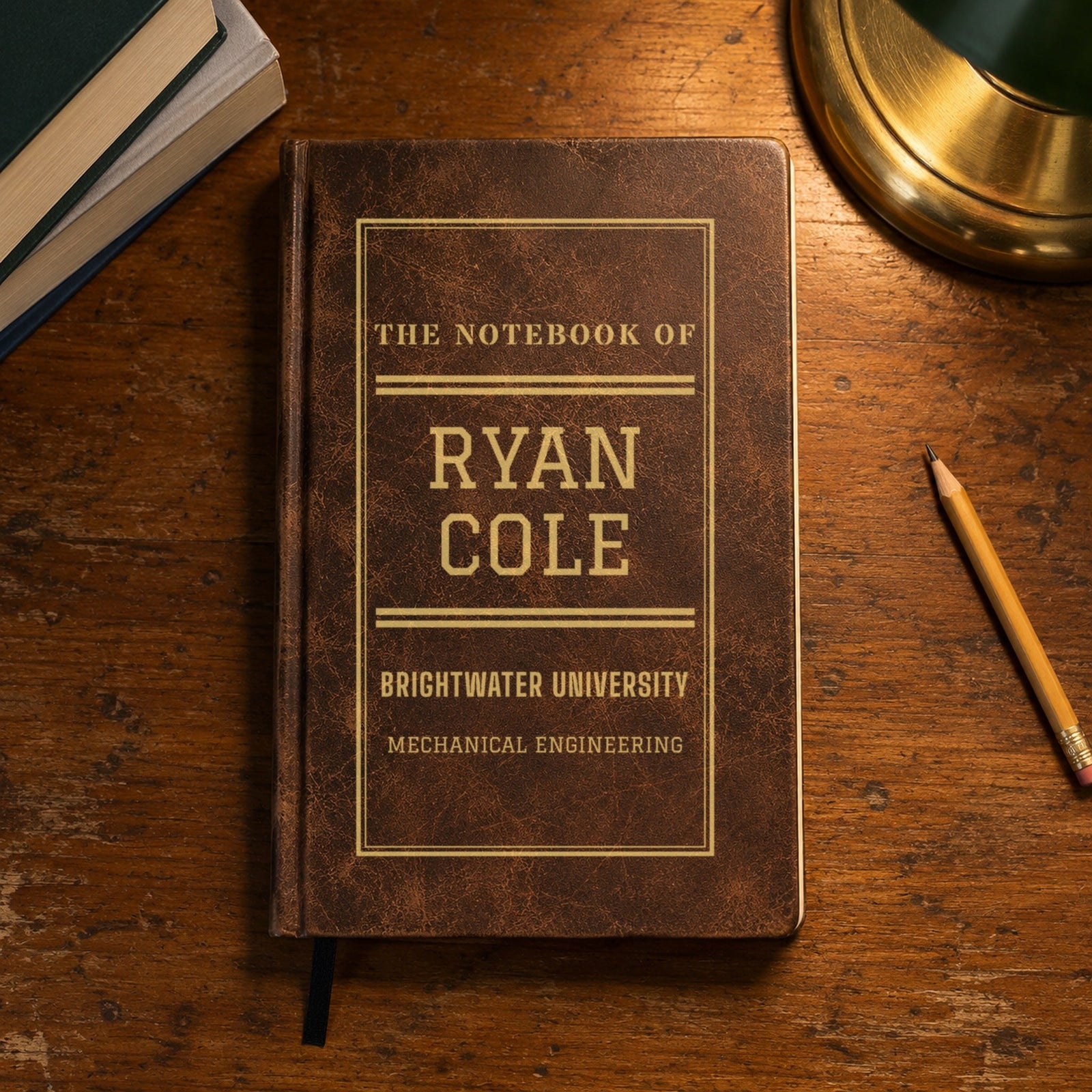 College journal in brown with gold engraving: The Notebook Of Ryan Cole, Brightwater University, Mechanical Engineering, on a library table, a gift for college guys