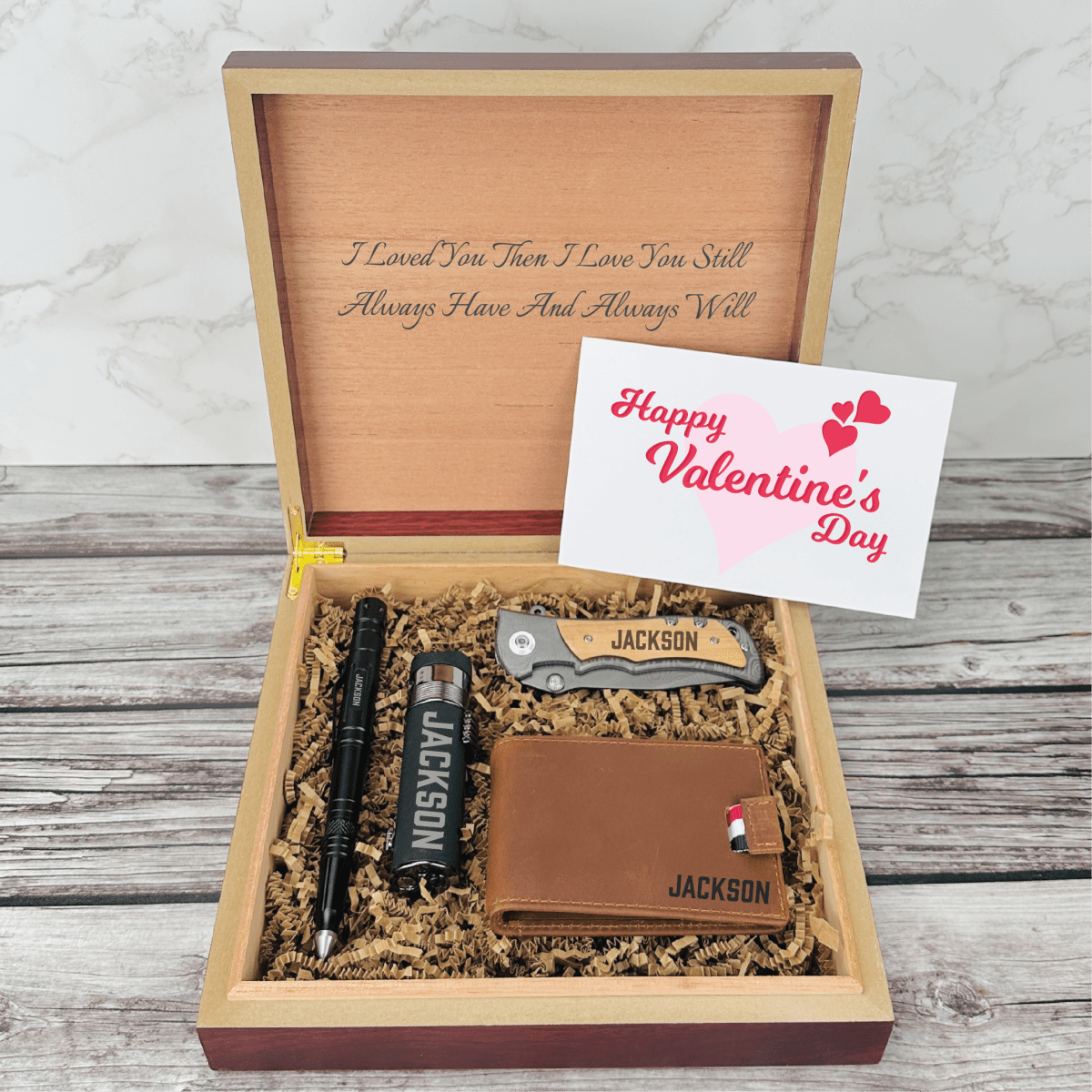 Personalized Valentine’s Day gift set for men featuring a tactical pen, triple torch lighter, wallet, titanium-coated knife, and engraved wooden box with custom name and message.