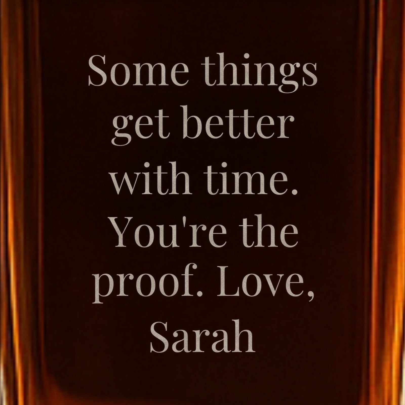 Close-up of a back message engraved on the bourbon decanter: Some things get better with time. You're the proof. Love, Sarah, a gift for whiskey lovers
