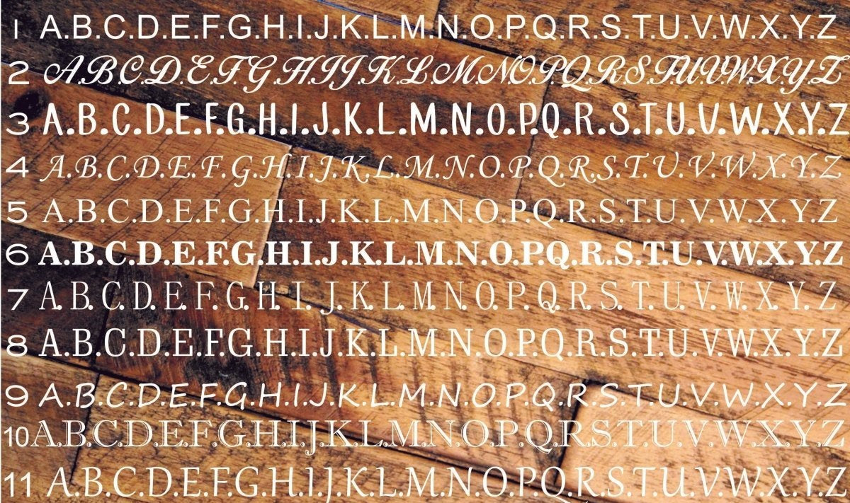 Font chart for the custom tie clip showing all 11 engraving font choices, numbered 1 to 11, set over a light wood background