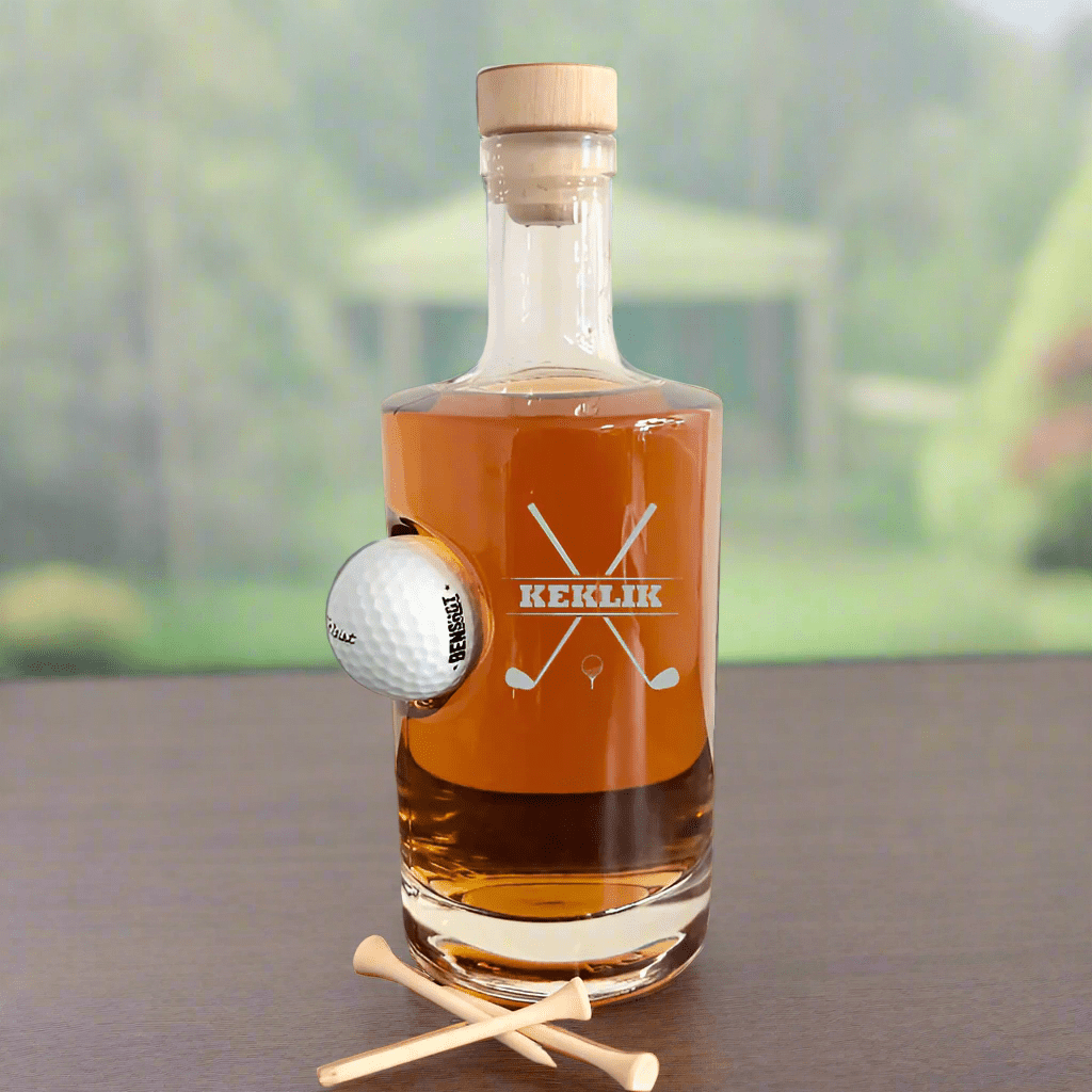 Personalized glass golf decanter with an embedded golf ball, engraved with "KEKLIK" and crossed golf clubs design.