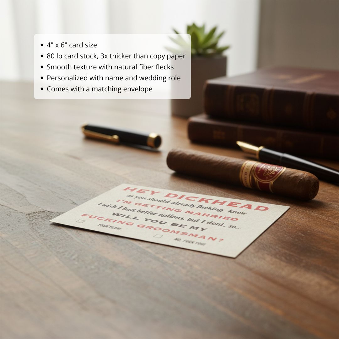 Cream card with red sample text reading "Hey Dickhead" displayed on wooden desk alongside cigar, pens, and leather-bound books