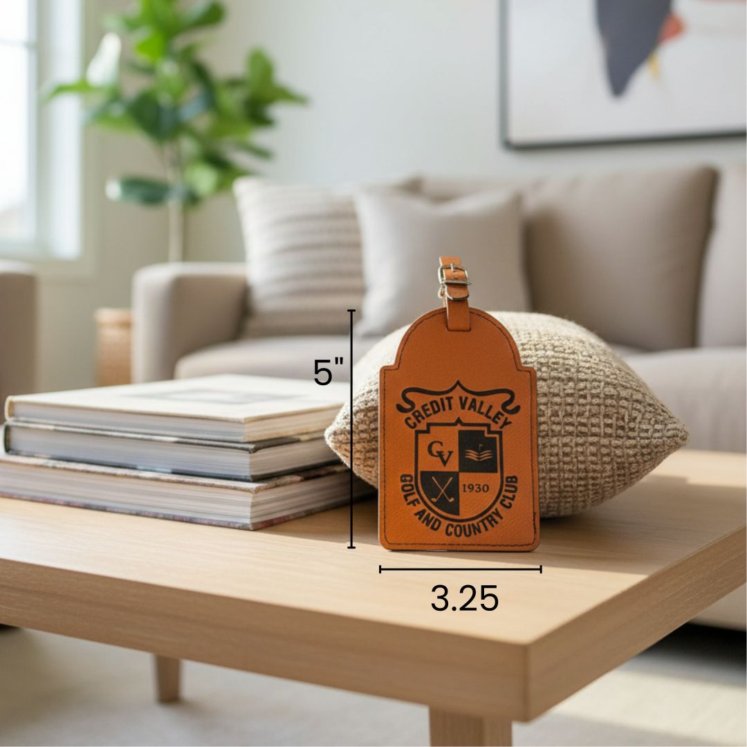 Tan vegan leather golf bag tag with embossed "Credit Valley Golf and Country Club" crest and leather strap, shown on wood table with scale indicating 5" height and 3.25" width