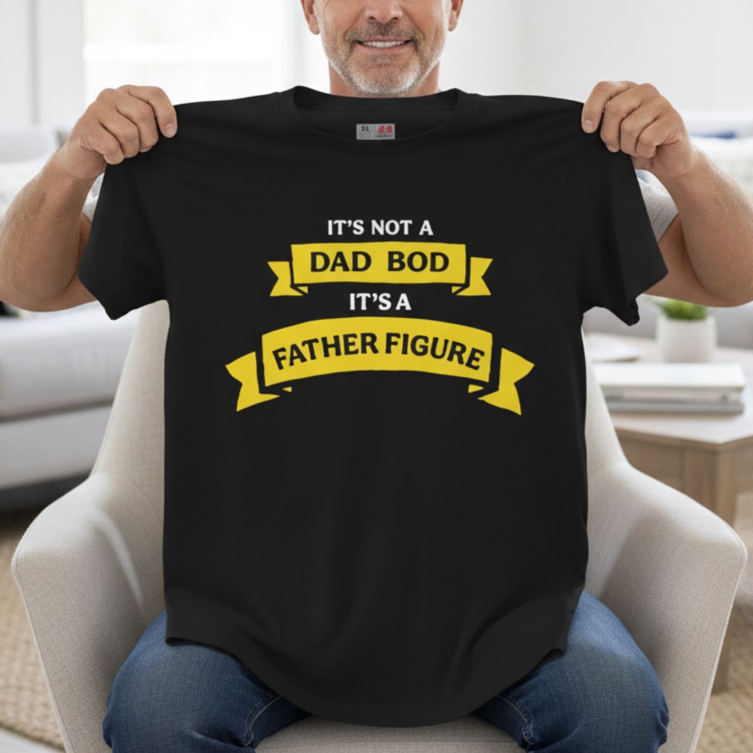 Man holding black t-shirt with yellow banner text reading "It's not a dad bod, it's a father figure