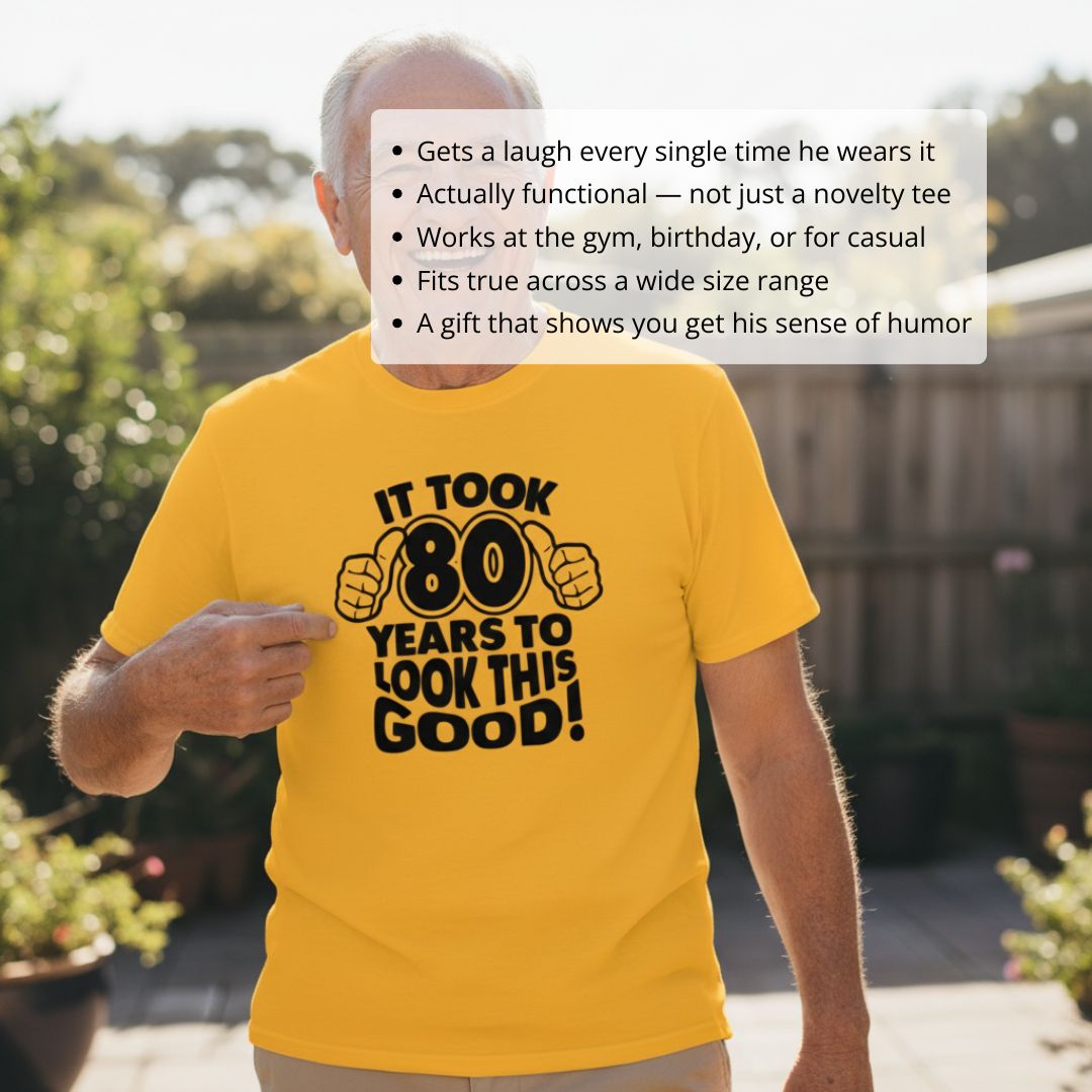 Older man wearing gold t-shirt with black text reading "It took 80 years to look this good" and thumbs-up graphic, standing outdoors in backyard setting.