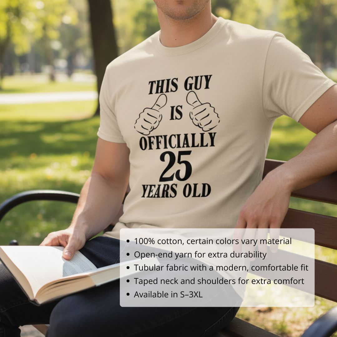 Cream t-shirt with black printed design reading "This Guy is Officially 25 Years Old" with dual thumbs-up graphics, worn outdoors while seated.