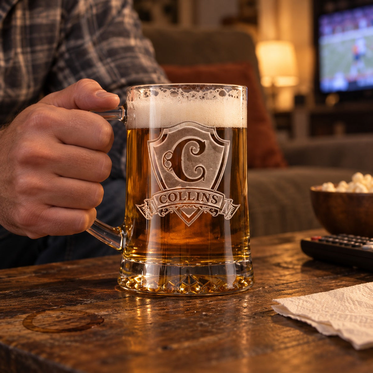 Man holding a personalized pub beer mug sand carved with a C initial and COLLINS on the shield banner during a game night at home.